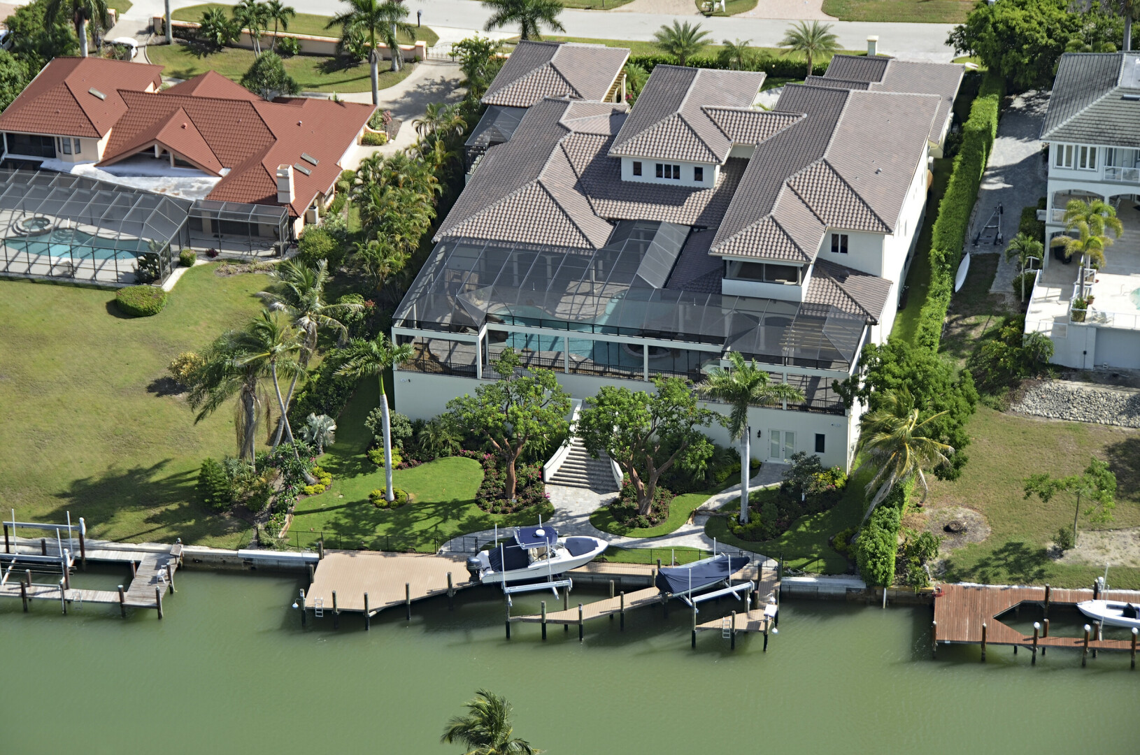 Aerial view of waterfront luxury home with a private boat deck, Naples FL